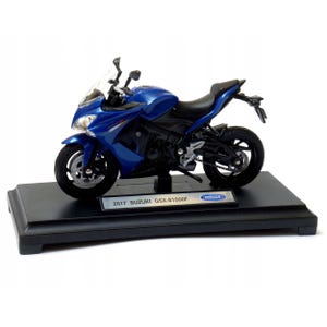 May include: A blue 2017 Suzuki GSX-S1000F motorcycle model on a black display stand. The model features a detailed design with black tires, a black seat, and a clear windshield. The stand has a silver label with the model's name.