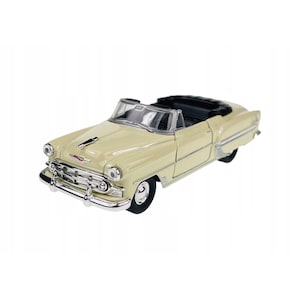 Puede incluir: Modelo de coche descapotable vintage color crema con detalles cromados. El coche de juguete tiene un interior negro y una parrilla delantera detallada. El coche es de diseño clásico, probablemente de mediados del siglo XX.