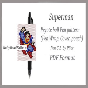 May include: A black pen with a Superman-themed peyote stitch pen wrap. The wrap features a pixelated image of Superman in his iconic blue, red, and yellow costume. Text on the image includes "Superman" and "Peyote ball Pen pattern".