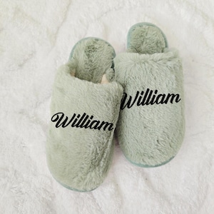 Sage green personalized slippers with the name William, displayed on fluffy white background — cozy custom gift idea.