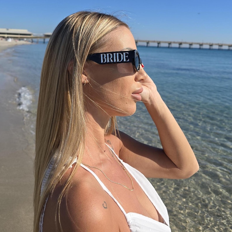 Black bride sunglasses with bold “BRIDE” text, bridal party sunglasses for bride-to-be, chic wedding weekend eyewear, honeymoon beach sunglasses, modern bridal accessory for bachelorette celebration and destination wedding.