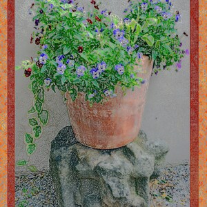 May include: A terracotta pot filled with purple and blue pansies sits on a grey stone base. The pot is surrounded by green foliage and the flowers are in full bloom.