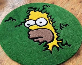 May include: A circular green rug with a yellow cartoon character's face in the centre. The character has a surprised expression, with a brown mouth and large white eyes. The rug is placed on a wooden floor.