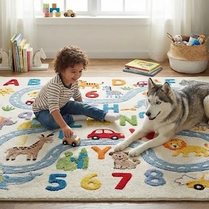 May include: A child and a dog are playing on a colorful rug with a road design, animals, and numbers. The rug features a light background with a blue road, and various animal illustrations. The child is playing with a wooden car.