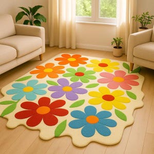 Puede incluir: Una colorida alfombra con forma de flor con un fondo color crema. La alfombra presenta grandes y vibrantes flores en tonos de rojo, naranja, amarillo, verde, azul y morado. Hojas verdes están dispersas alrededor de las flores.