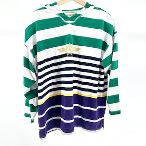 May include: A long-sleeved hooded shirt with horizontal stripes in green, white, navy blue, yellow, and purple. The shirt features a gold star emblem on the chest and is hanging on a wooden hanger.