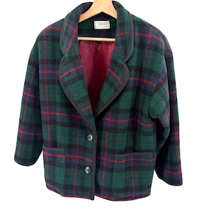 May include: A long-sleeve blazer featuring a dark green, navy blue, and red plaid pattern. The jacket has a notched collar, two black buttons for closure, and two front pockets. The interior is lined with a solid burgundy fabric and a Talbots Petites label.