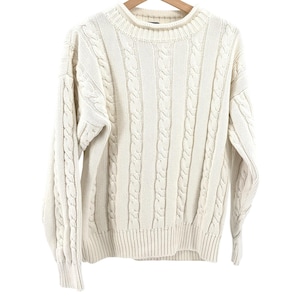 May include: A cream-colored long-sleeve sweater featuring a vertical cable knit pattern throughout the body and sleeves. The garment has a thick ribbed crew neckline, ribbed cuffs, and a ribbed hem, constructed with a textured knit design.