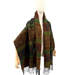 May include: A rectangular scarf featuring a repeating pattern of paisley motifs and geometric bands in shades of brown, olive green, and deep red. The fabric has a textured appearance and is finished with black fringe along the bottom edges.