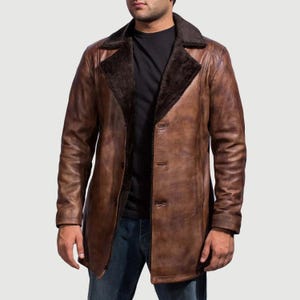 May include: A brown leather coat with a dark brown fur collar and lining. The coat has a button-down front and long sleeves. The coat is knee-length and appears to be made of high-quality leather.