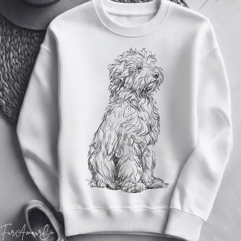 Może przedstawiać: Biała bluza z czarno-białą ilustracją siedzącego psa. Pies ma puszyste futro i patrzy w bok. Bluza jest gładka biała z okrągłym dekoltem.