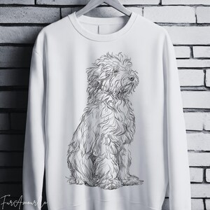 Może przedstawiać: Biała bluza z obszernym szkicem puszystego psa. Pies siedzi, a jego sierść jest oddana w cienkich liniach. Bluza wisi na drewnianym wieszaku na tle ceglanej ściany. Słowa "Fur Amour" znajdują się w lewym dolnym rogu.