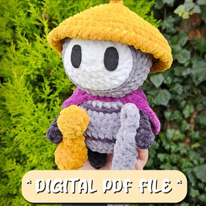Op de afbeelding: Een handgemaakte gehaakte pop met een gele hoed, grijze body en paarse cape. De pop houdt een kleine gele figuur en een grijze staf vast. Tekst op de afbeelding luidt "SHERMA Crochet Pattern" en "DIGITAL PDF FILE".