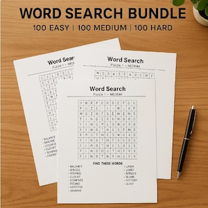 May include: A bundle of word search puzzles on white paper, with the text "WORD SEARCH BUNDLE" at the top. The bundle includes 100 easy, medium, and hard puzzles. A black pen rests on the wooden surface.