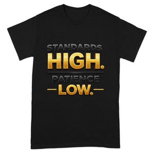 May include: Black t-shirt with the text "STANDARDS HIGH. PATIENCE -LOW." in gold and gray lettering. The shirt is a classic crew neck style, suitable for casual wear.