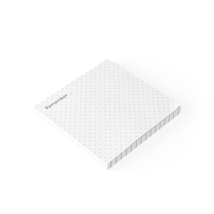 May include: A square stack of white sticky notes featuring a light gray polka dot pattern across the surface. The top sheet includes the text "Remember..." printed in a simple black font in the upper left corner of the paper pad.