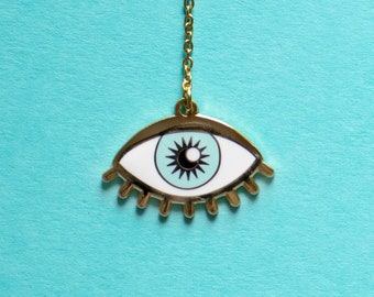 May include: A gold chain necklace with a white and blue evil eye pendant. The eye is outlined in gold and has a black pupil.