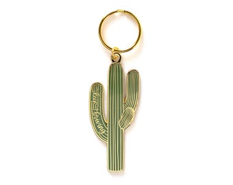 May include: Gold-tone keychain featuring a green cactus with the text "Keep Growing" on the side.