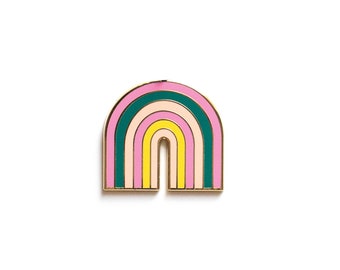 May include: A colorful enamel pin in the shape of a rainbow. The pin features a gold outline and layers of pink, green, yellow, and cream-colored enamel. The rainbow design is a cheerful accessory.