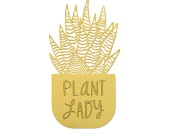 May include: Gold-colored metal bookmark with a cutout design of a potted plant and the text "Plant Lady".