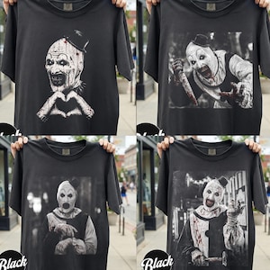 May include: A collection of four black short-sleeve t-shirts, each featuring a graphic print of a clown character with white face paint, a small black top hat, and blood-like splatters on the clothing and hands in various poses.