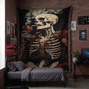 Könnte beinhalten: Große schwarze Wandtapete mit einer detaillierten Illustration eines rauchenden Skeletts, verziert mit einem Kreuz und Ketten. Die Tapete hängt an einer Backsteinmauer über einem Bett mit grauer Bettwäsche. Zusätzliche Schädelkunst dekoriert die Wand.