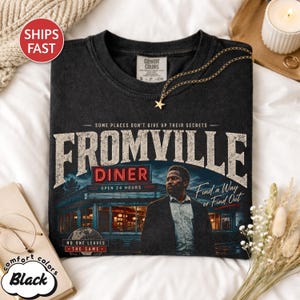Peut inclure: T-shirt noir Comfort Colors avec un motif graphique de la s&eacute;rie Fromville. Le motif comprend le texte "Fromville Diner" avec une image d'un restaurant et la phrase "Find a Way or Find Out."