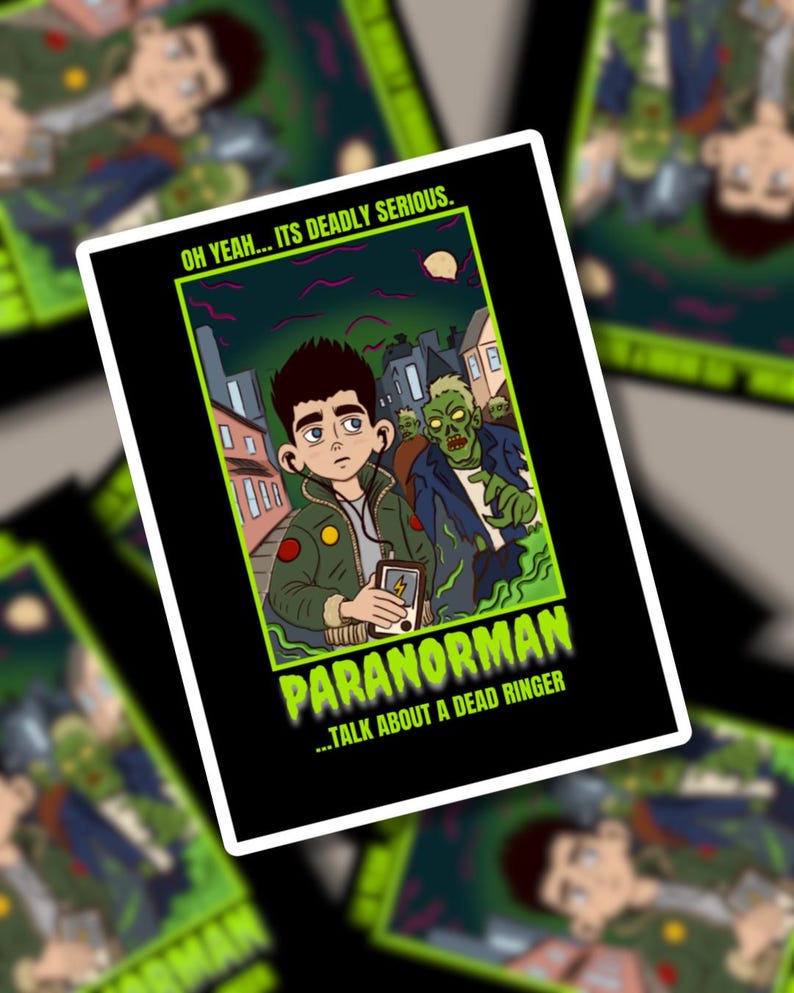 May include: A rectangular sticker with a cartoon illustration from the film Paranorman. The image depicts a young man and a zombie in a city scene. Text includes "OH YEAH... ITS DEADLY SERIOUS" and "PARANORMAN...TALK ABOUT A DEAD RINGER."