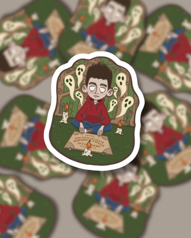 May include: A sticker with a cartoon illustration of a person in a red hoodie sitting cross-legged before a Ouija board. White ghost figures and lit candles surround the person. The background is a green forest scene.