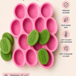 May include: Pink silicone mould with oval cavities, holding green oval soaps. The mould has the text "SILICONE MOLD" and "High-Quality Silicone". The dimensions are 8.9cm x 6.4cm with a thickness of 2.5cm. The soaps are labeled "OSCAR LES VACANCES".