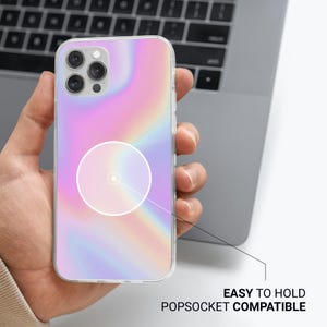 May include: A clear phone case with a pastel rainbow design. The case is shown with a popsocket circle and the text "EASY TO HOLD POPSOCKET COMPATIBLE". The phone case is held in a person's hand.