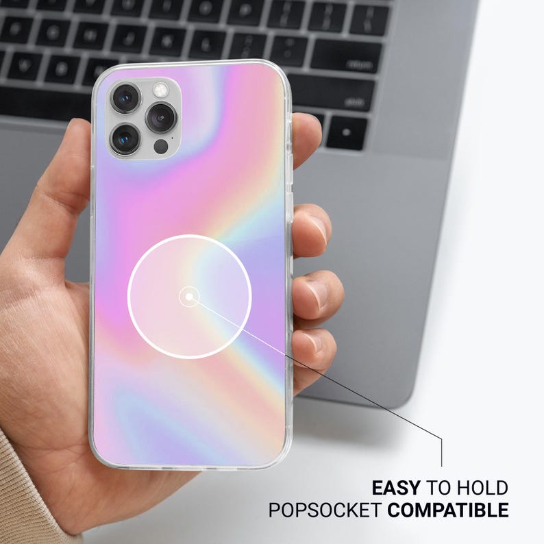 May include: A clear phone case with a pastel rainbow design. The case is shown with a popsocket circle and the text "EASY TO HOLD POPSOCKET COMPATIBLE". The phone case is held in a person's hand.