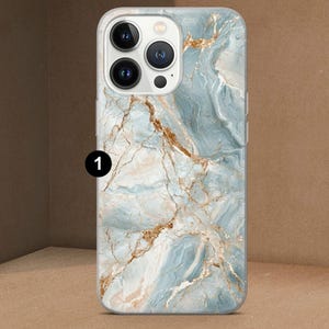 K&ouml;nnte beinhalten: Eine Smartphone-H&uuml;lle mit Marmordesign. Die H&uuml;lle zeigt ein Muster aus blauen, wei&szlig;en und goldenen Wirbeln, das einen nat&uuml;rlichen Stein-Look erzeugt. Die Kameralinsen des Telefons sind oben sichtbar.