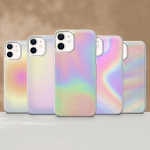 Puede incluir: Se muestran cinco fundas de teléfono iridiscentes con un borde transparente. Las fundas tienen un acabado liso y brillante con un patrón arremolinado colorido de tonos rosas, amarillos, verdes y azules. Las fundas están dispuestas en fila.