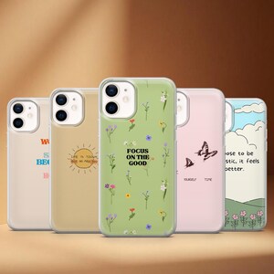 Pode incluir: Uma coleção de capas de telemóvel com vários designs. Uma capa é verde claro com padrões florais e o texto "FOCUS ON THE GOOD". Outras capas apresentam um sol, borboletas e citações inspiradoras. As capas estão em fila.