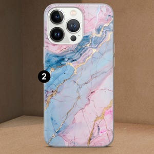 K&ouml;nnte beinhalten: Eine Handyh&uuml;lle mit Marmordesign. Die H&uuml;lle zeigt eine Mischung aus Rosa, Blau und Gold. Die Zahl "2" ist in der oberen linken Ecke aufgedruckt. Die H&uuml;lle hat einen transparenten Rand.
