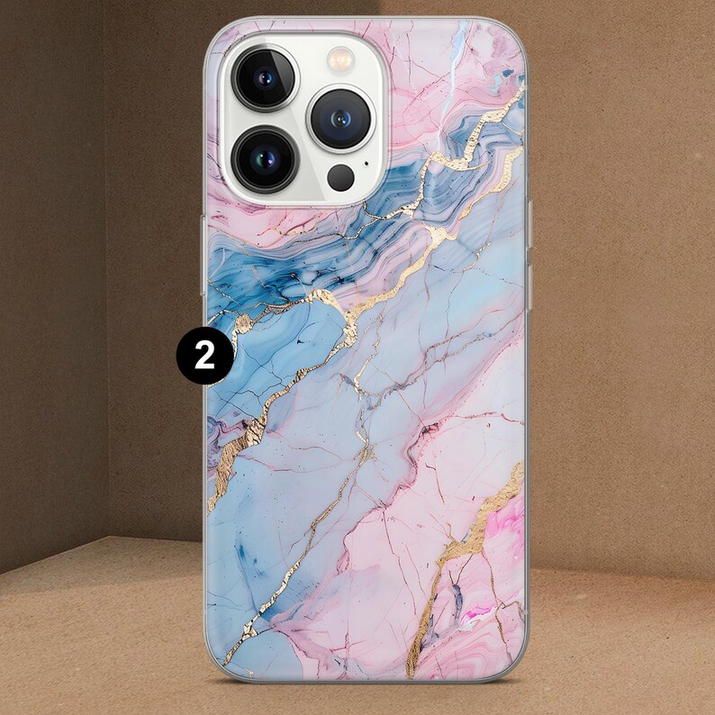 K&ouml;nnte beinhalten: Eine Handyh&uuml;lle mit Marmordesign. Die H&uuml;lle zeigt eine Mischung aus Rosa, Blau und Gold. Die Zahl "2" ist in der oberen linken Ecke aufgedruckt. Die H&uuml;lle hat einen transparenten Rand.