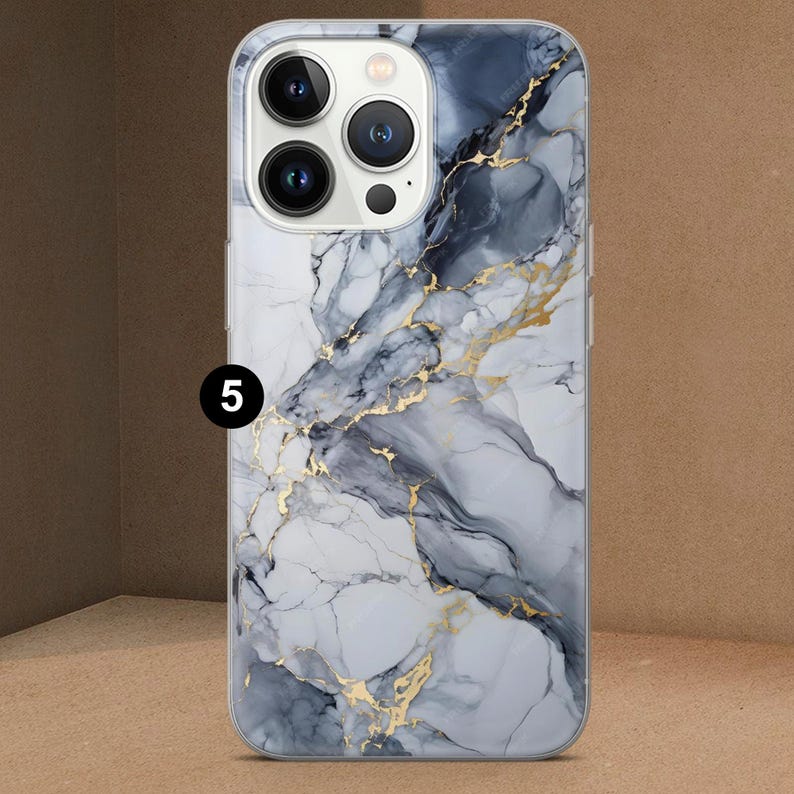 K&ouml;nnte beinhalten: Eine Handyh&uuml;lle mit Marmordesign. Die H&uuml;lle hat ein Muster aus wei&szlig;en, grauen und marineblauen Wirbeln mit goldfarbenen Adern. Die Handyh&uuml;lle hat einen transparenten Rand und die Zahl "5" ist sichtbar.