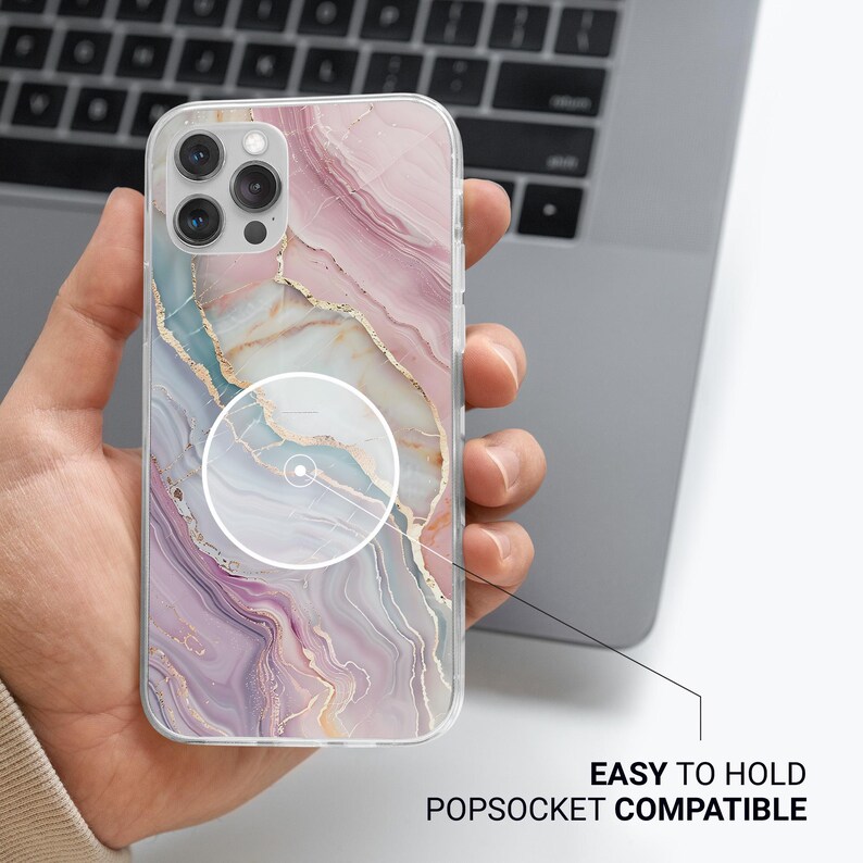 K&ouml;nnte beinhalten: Eine transparente Handyh&uuml;lle mit Marmormuster in Rosa-, Gold- und Blaut&ouml;nen wird in einer Hand gehalten. Die H&uuml;lle hat einen PopSocket-Aufsatz. Der Text auf dem Bild lautet "EASY TO HOLD POPSOCKET COMPATIBLE".