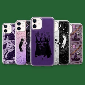 May include: A selection of phone cases with mystical designs. The cases feature illustrations of black cats, hands, moons, stars, witch hats, and botanical elements in purple, black, and white. The cases are displayed against a green background.