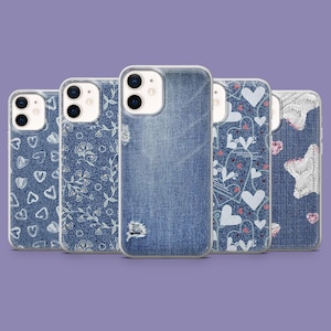 Pode incluir: Cinco capas de telefone com vários designs inspirados em jeans. As capas apresentam padrões de corações, vinhas florais e texturas de jeans desgastados. As capas estão em uma fileira contra um fundo roxo.