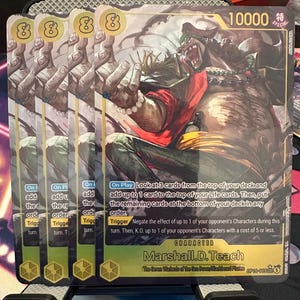 May include: Four identical trading cards featuring the character Marshall D. Teach from One Piece. The cards display a power level of 10000, text describing game mechanics, and the character in a dynamic pose with a red shirt and yellow sash.