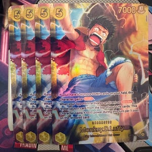 Könnte beinhalten: Mehrere One Piece Sammelkarten mit einer farbenfrohen Illustration von Monkey D. Luffy. Die Karten zeigen den Charakter mit roter Weste und blauen Shorts, Text wie "7000" und den Namen des Charakters.