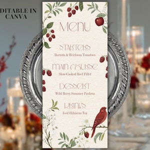 Puede incluir: Una taza de cerámica blanca con un asa negra y el texto "But First, Coffee" en negrita negra. La taza se encuentra sobre un fondo borroso, sugiriendo un ambiente acogedor.