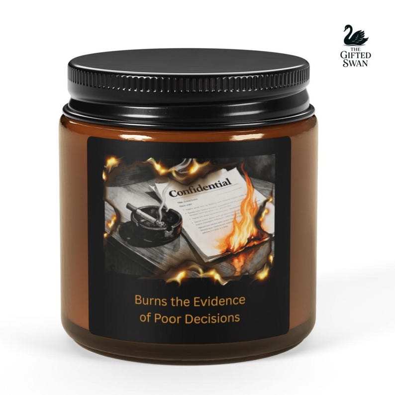 May include: A brown glass jar candle with a black lid. The label features an image of a burning document with the word "Confidential" and a lit cigarette in an ashtray. The text "Burns the Evidence of Poor Decisions" is below the image.