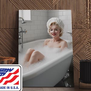 May include: A framed print featuring a woman in a white bathtub filled with bubbles. The woman is wearing a white shower cap and smiling. The print has a white border and the text "MADE IN U.S.A." with a flag design.