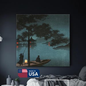 May include: A canvas print of a Japanese-style landscape scene. The artwork depicts figures in a boat with lanterns, a tree, and buildings on the water. The color palette includes dark blues, greens, and reds. The print is labeled "Made in USA".