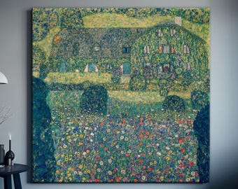 May include: A large, framed artwork depicting a house covered in greenery, surrounded by a vibrant field of colorful flowers. The painting is displayed on a gray wall, with a small table and decorative items in front.