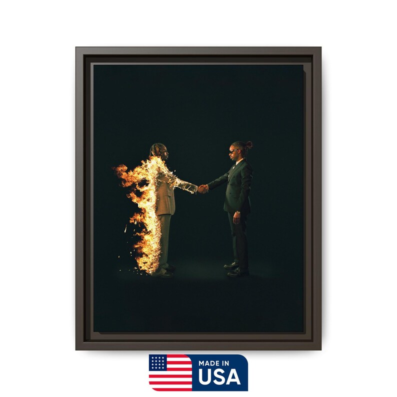 Puede incluir: Obra de arte enmarcada que representa a dos figuras con trajes estrech&aacute;ndose la mano sobre un fondo oscuro. Una figura est&aacute; en llamas. La obra est&aacute; enmarcada en un marco marr&oacute;n oscuro e incluye una etiqueta "MADE IN USA".