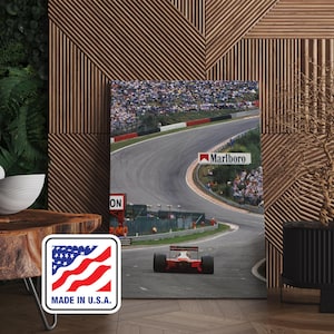 Puede incluir: Impresión enmarcada de un coche de carreras de Fórmula 1 en una pista. La imagen muestra un coche rojo y blanco, espectadores y el logotipo de Marlboro. La impresión se presenta contra una pared de madera. Incluye una pegatina "Made in U.S.A.".